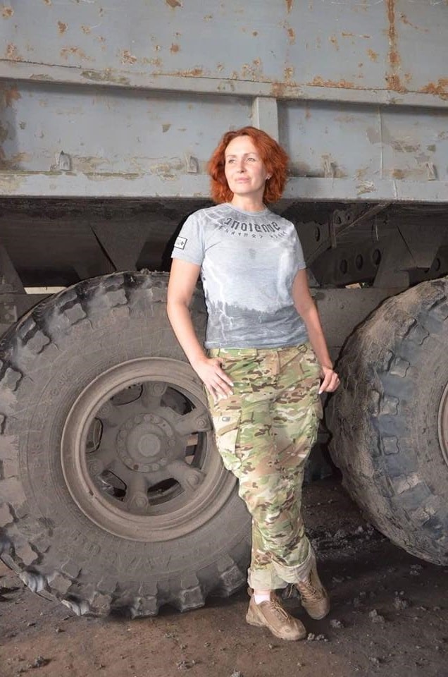 Юлія Кузьменко позує в камуфляжних штанах на фоні колеса